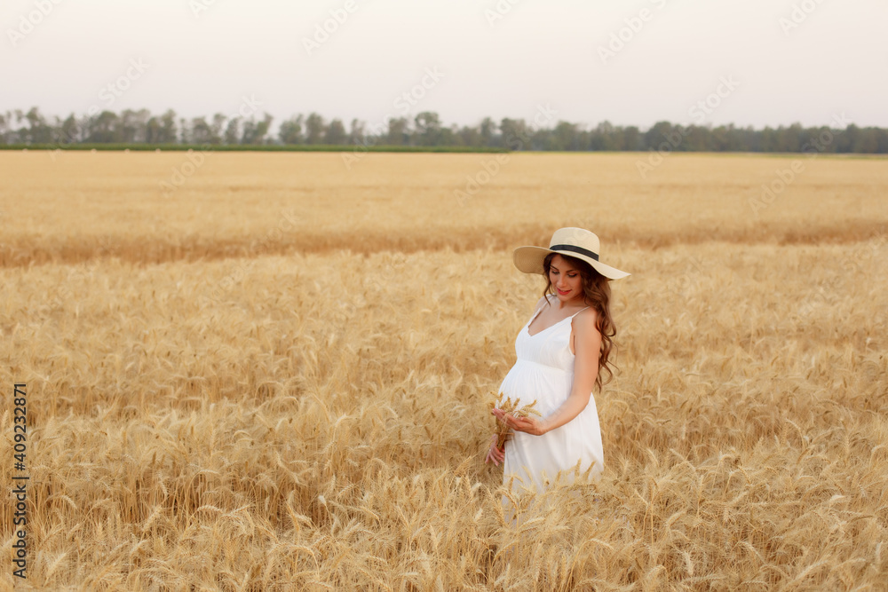 pregnant woman in a straw hat in a field of wheat pregnant woman in a straw hat in a field of wheat