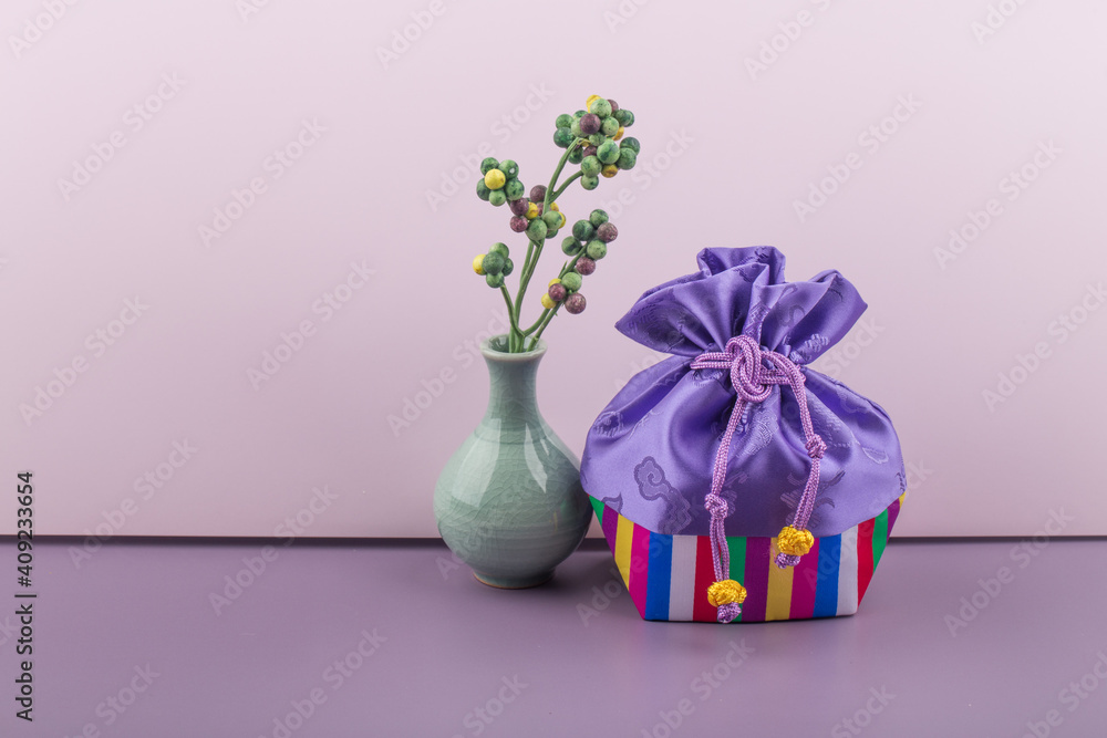 Korean traditional gift lucky bag with various decorations on violet background.