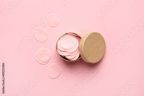 Open small round gift box with circle confetti on pale pink background . Flat lay, mock-up