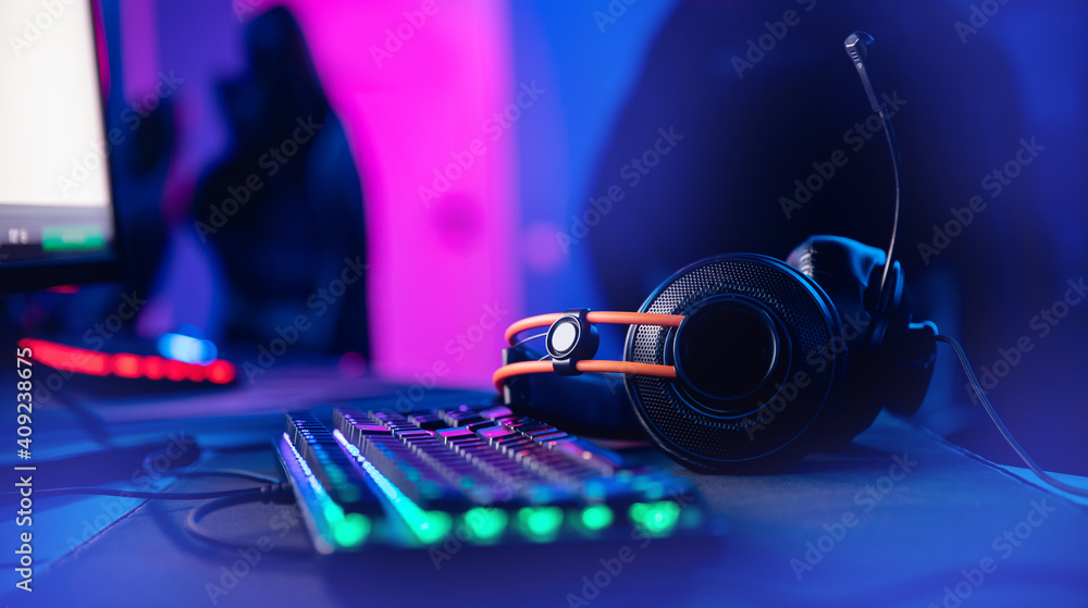 Happy professional player streaming esport tournament using microphone and  headphones, enjoying a multiplayer game. Competitive gamer playing online  video game at home. Neon color. Cyber sport concept Stock Photo