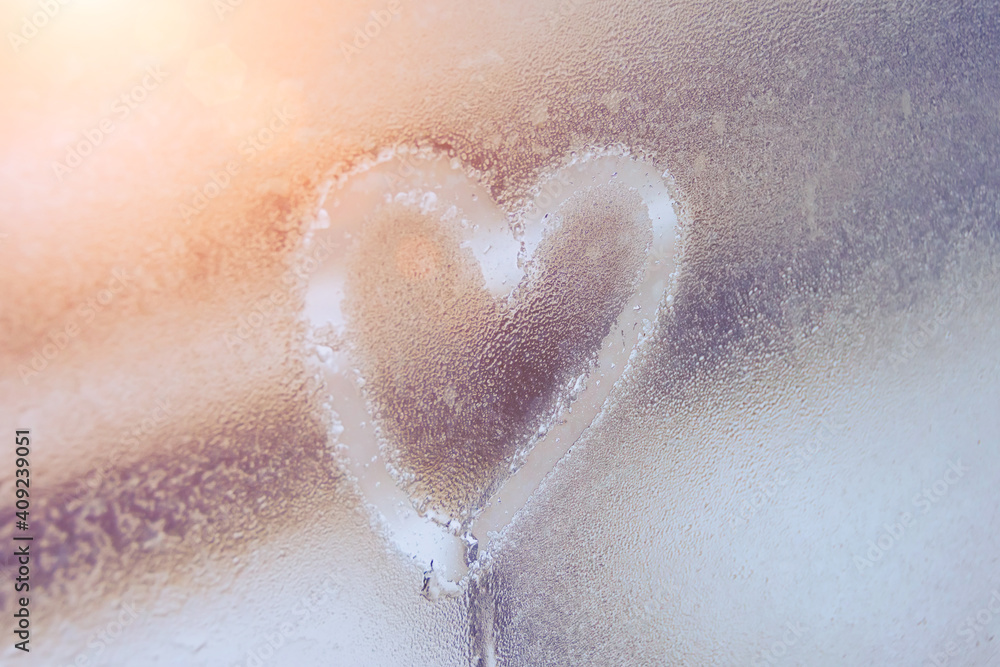 Fototapeta premium Heart on misted glass. Heart on a window background. Heart symbol of love drawn on the glass.