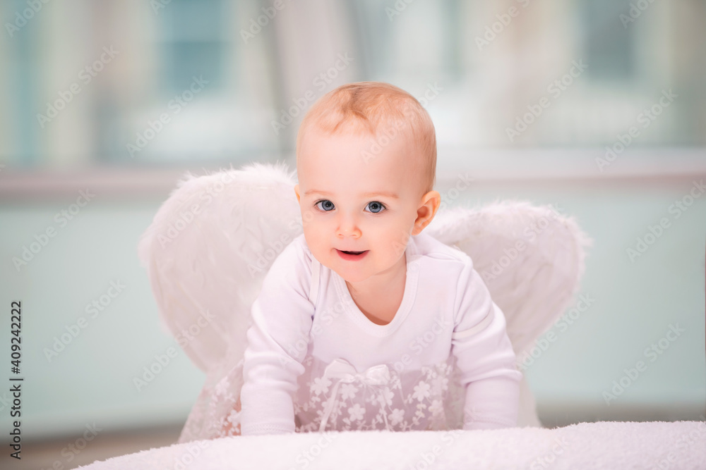 Portrait of cheerful mischievous baby with white angel wings crawling towards viewer Portrait of cheerful mischievous baby with white angel wings crawling towards viewer