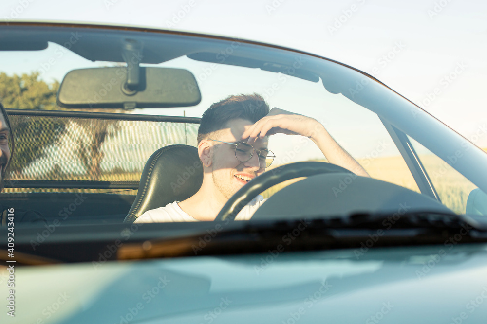 Naklejka premium Laughing young boy with blonde hair with hand near the face in the car