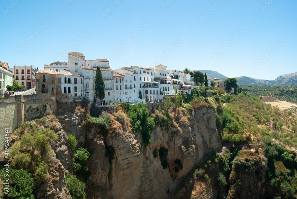 Ronda city Spain. Dramatic view of the El Tajo gorge with handsome town houses on the cliff tops. Historic Spanish city. Beautiful panorama.