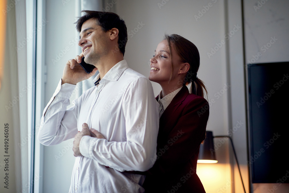 A young couple enjoying together in the hotel room at their business trip. Hotel, business, people A young couple enjoying together in the hotel room at their business trip. Hotel, business, people