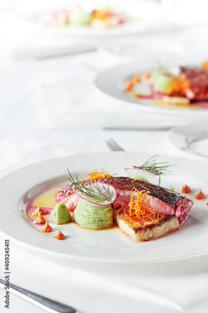 Tender dorado fillet with vegetables and basil. Banquet festive dishes. Gourmet restaurant menu. White background. Tender dorado fillet with vegetables and basil. Banquet festive dishes. Gourmet restaurant menu. White background.