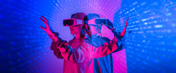 Young woman using glasses of virtual reality on dark background. Smartphone using with VR headset,virtual reality,future technology concept.Asian woman using VR glasses in colorful neon lights.