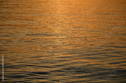 Gentle waves with reflection of sunset on the sea