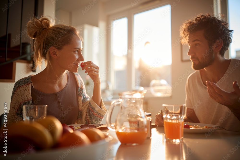 A happy young couple having a pleasant talk while having a breakfast. Relationship, love, together, breakfast