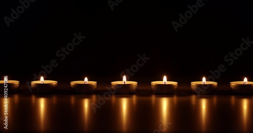 Candles glowing against dark background
