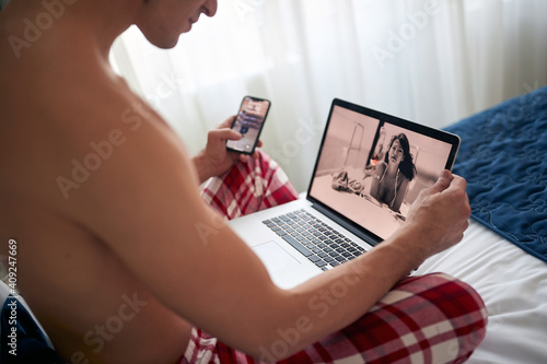 A young man at the hotel room enjoying a dating site. Hotel, vacation, dating, online