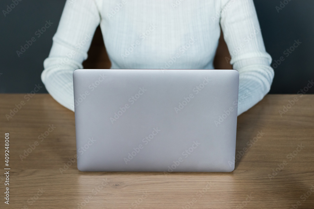 Fototapeta premium woman in white sweater working with laptop in office