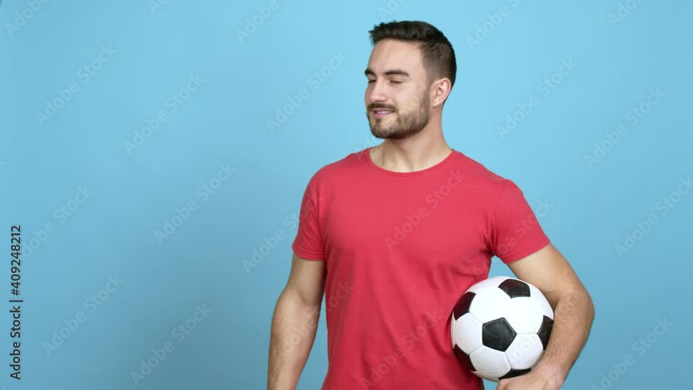 Caucasian handsome man holding a soccer ball extending hands to the side and inviting to come over isolated background Caucasian handsome man holding a soccer ball extending hands to the side and inviting to come over isolated background