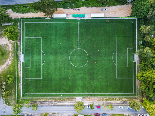 Aerial drone top view of the football soccer field with playing people, aerial view of the football field in the stadium Lampang Thailand