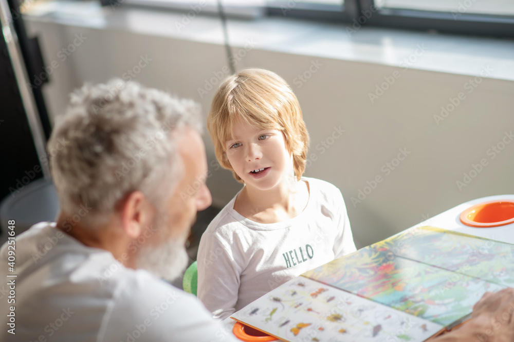 Obraz premium Boy learning animal species while reading a book