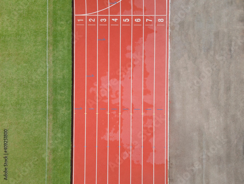 Aerial Top-down view of National Sports Center, Top view of red running tracks, and green grass lawn. Infrastructure for sports activities, running track, shot with a drone looking down