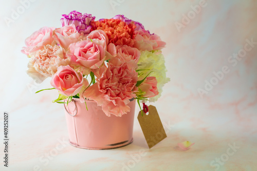 Fototapeta Naklejka Na Ścianę i Meble -  Mather's day concept. Colorful carnation and pink rose in a pink bucket