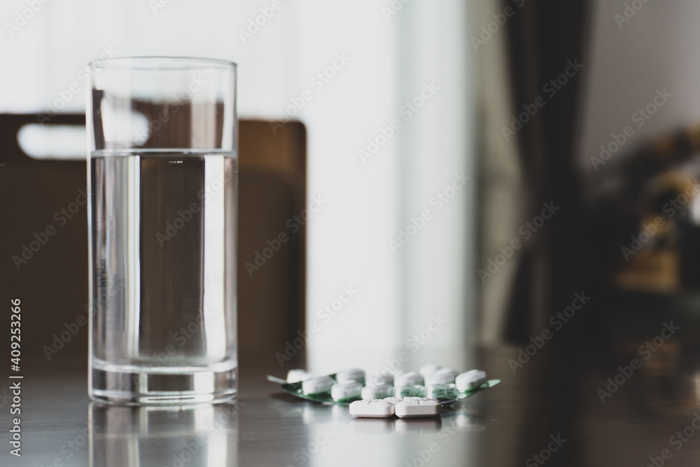Medicine with drinking water on table at home Medicine with drinking water on table at home