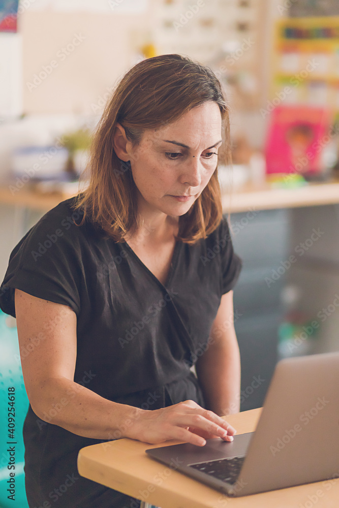 Elementary School teacher working on her laptop. Elementary School teacher working on her laptop.