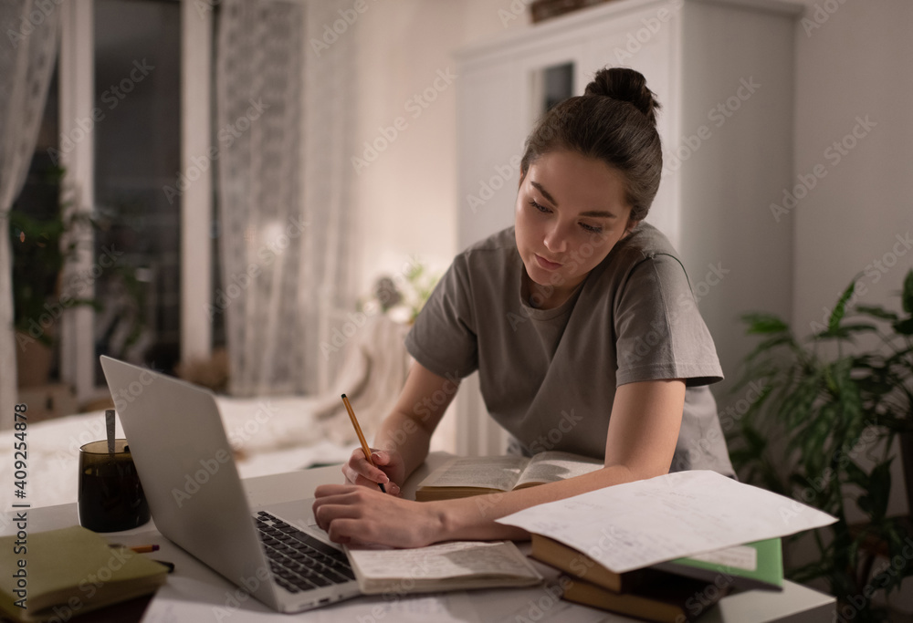 Student taking notes and preparing for exams at home Student taking notes and preparing for exams at home