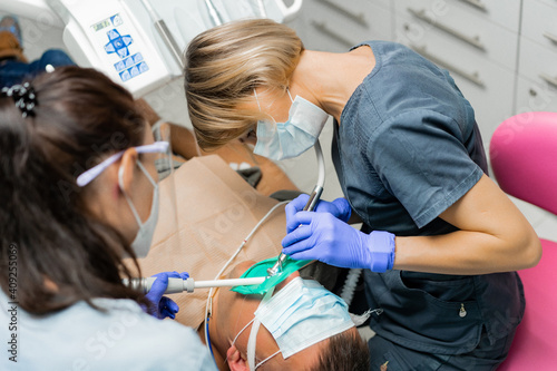 dentistry under general anesthesia. The dentist treats the patient under general anesthesia. dentist and assistant in the process.