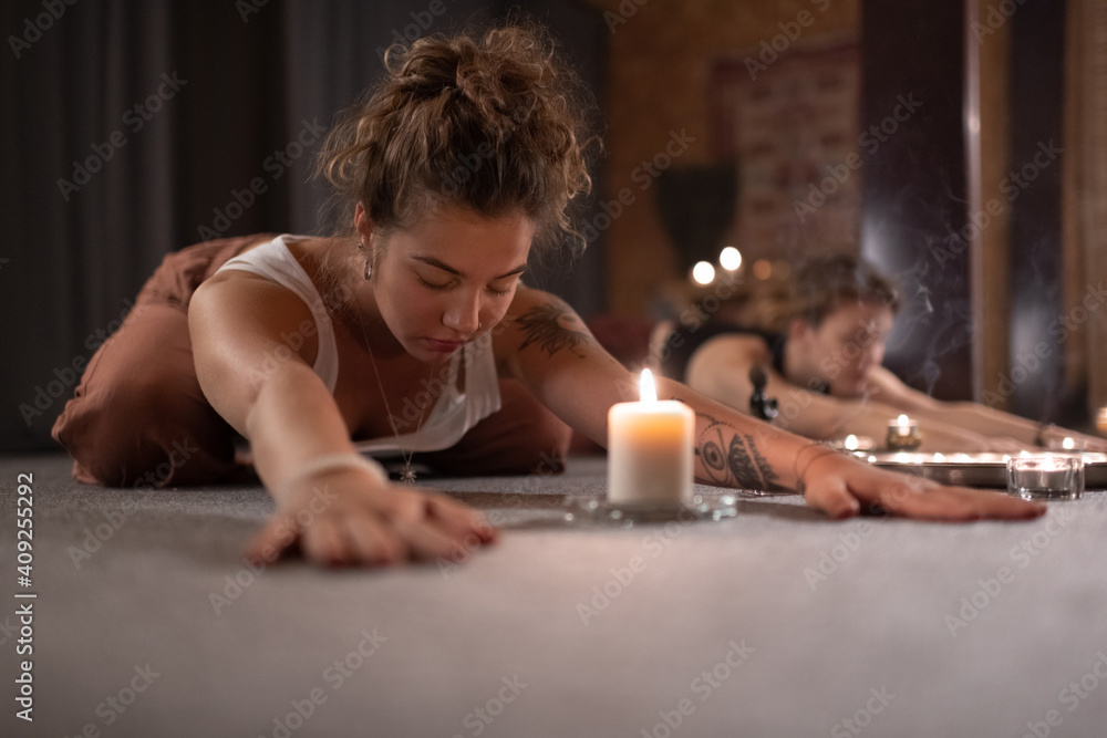 Woman doing Childs pose near candle Woman doing Childs pose near candle