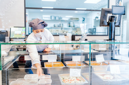 cook in her restaurant placing the portions in the display case