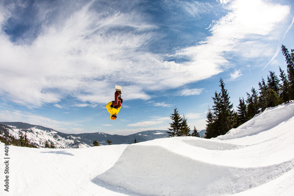 Young man in mid-air making snowboard jump
