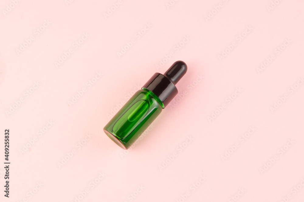 Small green bottle on pink background top view Small green bottle on pink background top view