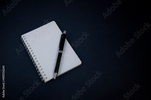 Notebook, pen, on blue background. top view copy space.