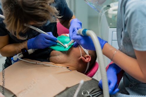dentistry under general anesthesia. Dentist treats a patient with rubber dam