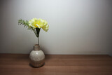 Yellow carnation flowers in vintage vase on wooden table, floor, gray cement wall Stylish stock image format for banner templates, text artwork, quotes, fonts, festivals