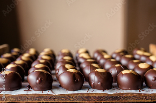 rows of neatly lined up chocolate candies spread out on a wooden board