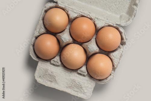 photo or picture of 6 eggs in a box, eggs in a photo with a brown background photo