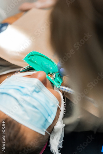 dentistry under general anesthesia. The dentist treats the patient under general anesthesia. dentist and assistant in the process.