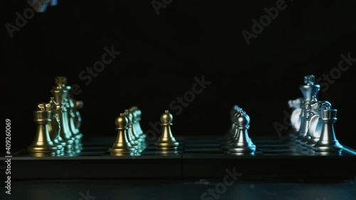 Game of chess. Male hand puts a white chess piece pawn on the chessboard on a black background ,Business planning and strategy ideas
