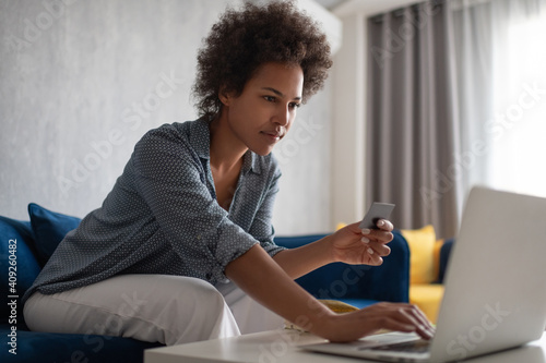 Ethnic female doing online shopping photo