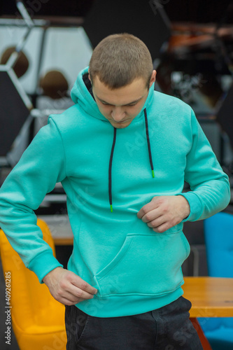 Handsome attractive European muscular man in turquoise hoodie photo