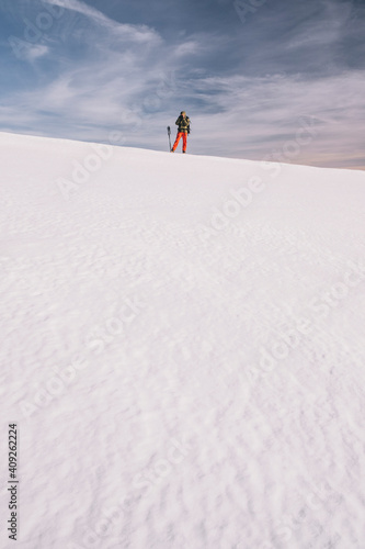 Young man taking a picture on a ice snow against cloudy sky, Gredos photo