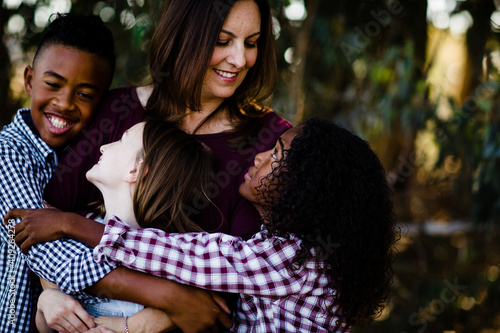 Mom & Kids Hugging at Looking at One Another photo