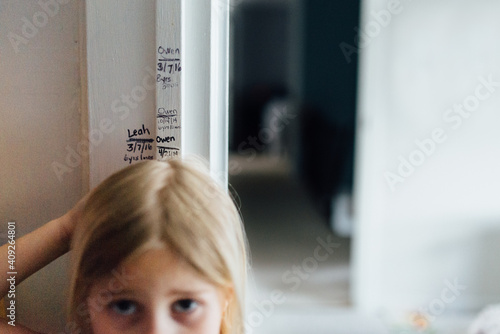 Measuring girl's height at home on door frame