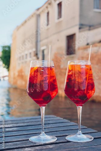 Two glasses of Spritz Veneziano cocktail served near the Venetian canal.  Popular italian summer aperitif drink. Venice background. © Iryna