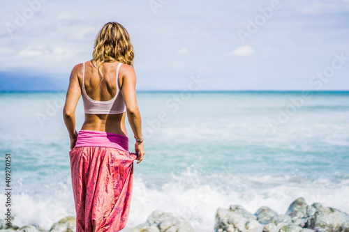Beautiful woman in yoga pants looking out towards ocean photo