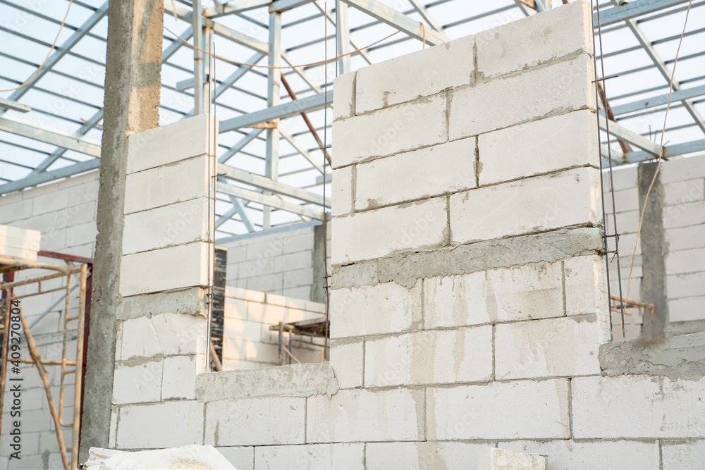 Obraz premium Aerated brick wall on site,lightweight cement brick wall and white lintel plaster to joint for reinforce at construction site.