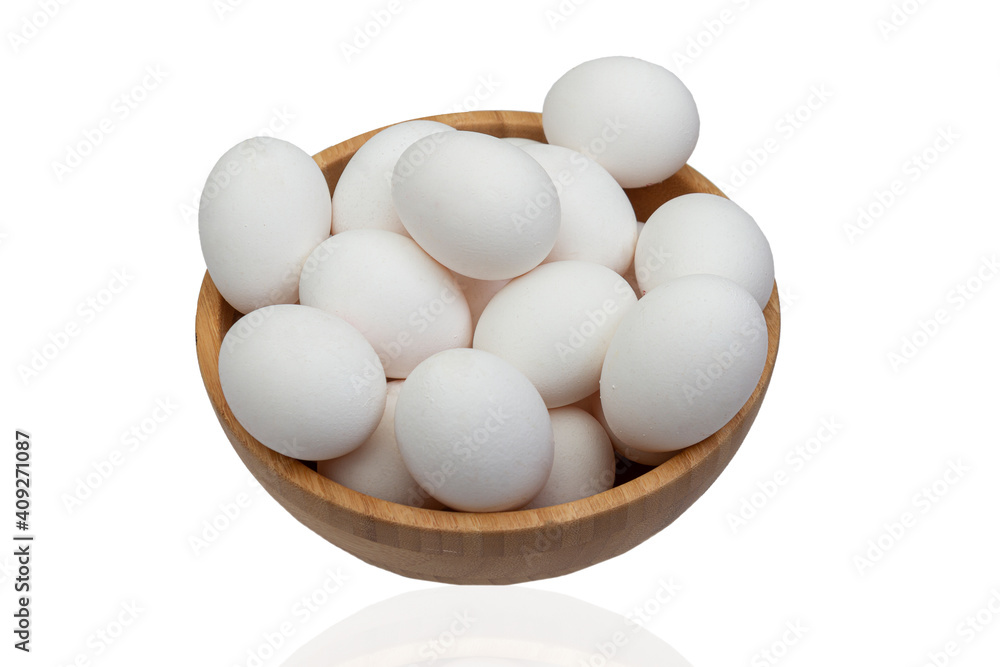 Many eggs lie in a wooden bowl on a white isolated background. Many eggs lie in a wooden bowl on a white isolated background.