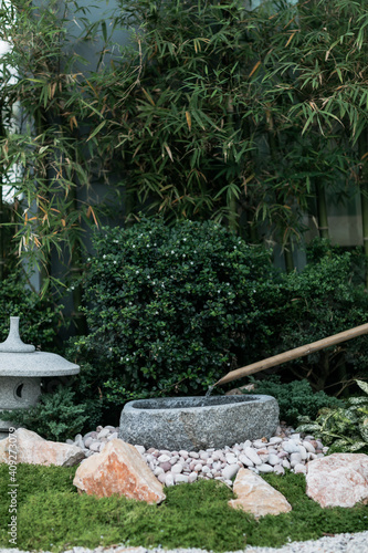 Beautiful manicured Japanese stone lantern in Japanese garden