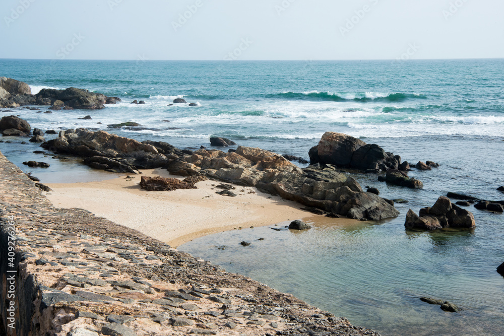 Coastal landscape with rocks, beach and calm sea at Galle, Sri Lanka on a sunny day