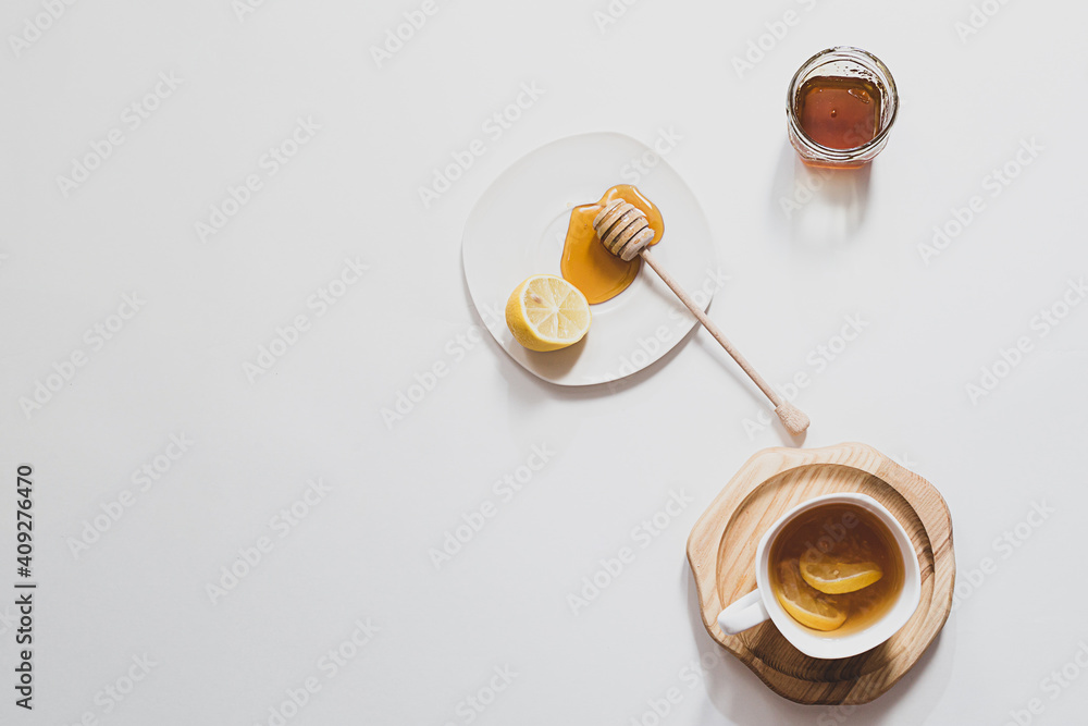Herbal tea with honey and lemon on a light background, healthy food concept. Minimalistic flat lay with copy space.