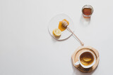 Herbal tea with honey and lemon on a light background, healthy food concept. Minimalistic flat lay with copy space.