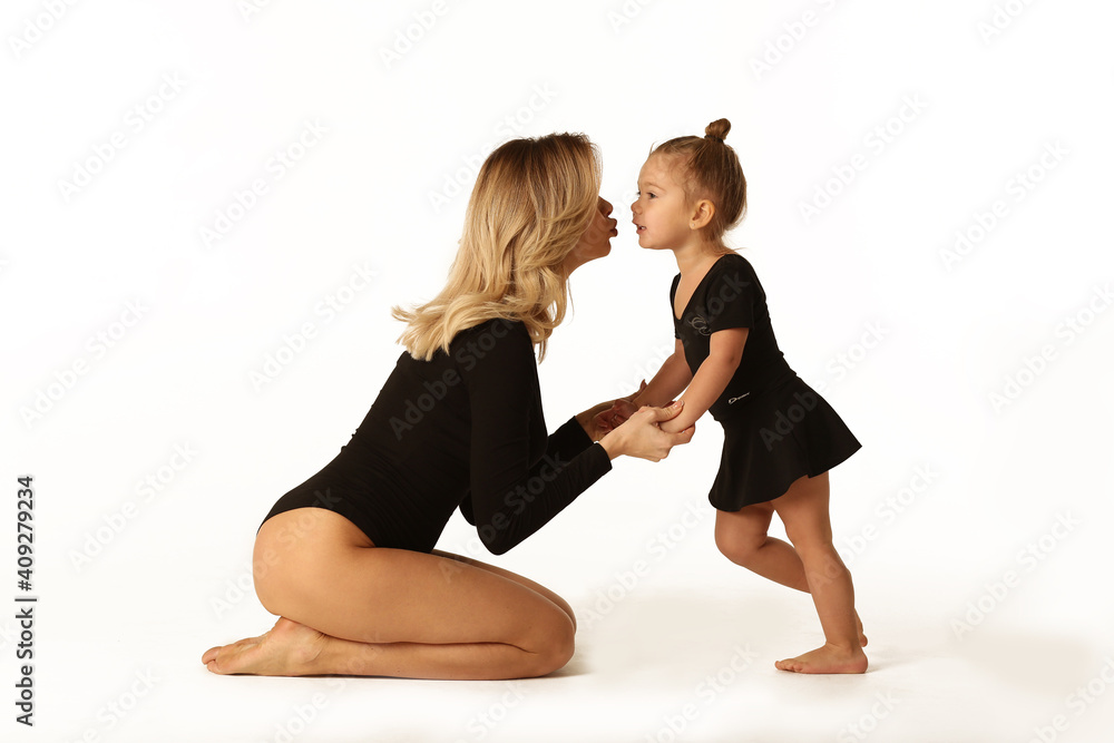 cute baby girl and mum in black bodies having fun full body studio portrait
